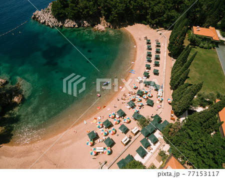 Colored sun umbrellas stand on the sand at the Royal Beach in Przno. View from above 77153117
