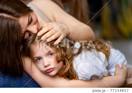 Mom cuddles with her daughter. happy family.  77154657