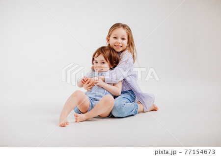 older sister hugs younger sister, and she runs away. restless children. older sister hugs younger sister, and she runs away. restless children. 77154673