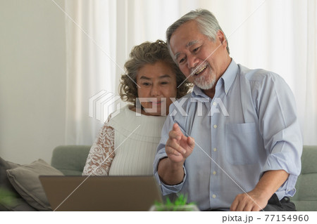 Couple Elderly Asian video conferent online with laptop at home. Couple Elderly Asian video conferent online with laptop at home. 77154960