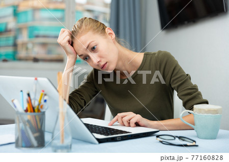 Tired woman working with laptop at the home 77160828