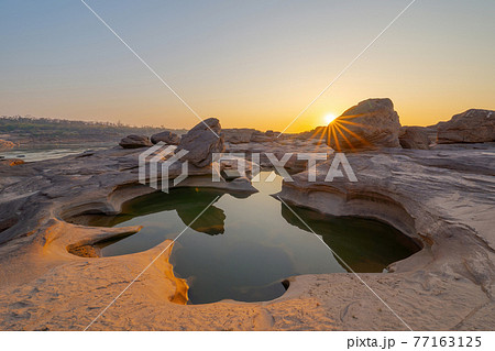 Sam Phan Bok, Ubon Ratchathani, Thailand. Dry rock reef in the Mekong River with mountain hills. Nature landscape background. Grand Canyon of Thailand. Sam Phan Bok, Ubon Ratchathani, Thailand. Dry rock reef in the Mekong River with mountain hills. Nature landscape background. Grand Canyon of Thailand. 77163125