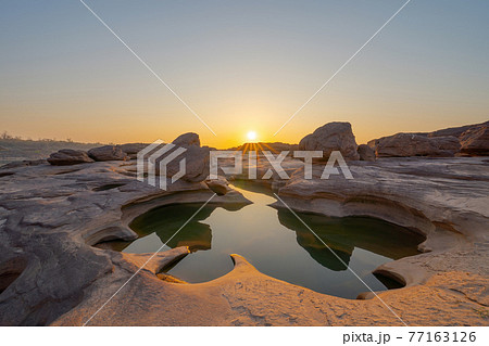 Sam Phan Bok, Ubon Ratchathani, Thailand. Dry rock reef in the Mekong River with mountain hills. Nature landscape background. Grand Canyon of Thailand. 77163126