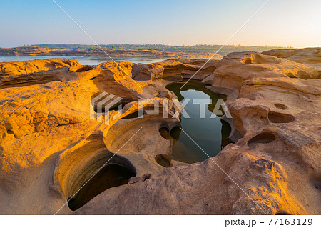 Sam Phan Bok, Ubon Ratchathani, Thailand. Dry rock reef in the Mekong River with mountain hills. Nature landscape background. Grand Canyon of Thailand. 77163129