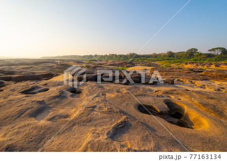 Sam Phan Bok, Ubon Ratchathani, Thailand. Dry rock reef in the Mekong River with mountain hills. Nature landscape background. Grand Canyon of Thailand. Sam Phan Bok, Ubon Ratchathani, Thailand. Dry rock reef in the Mekong River with mountain hills. Nature landscape background. Grand Canyon of Thailand. 77163134