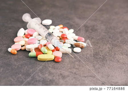 syringe and pills on dark background, close up syringe and pills on dark background, close up 77164886