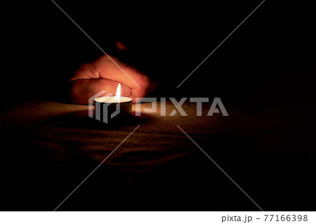 A candle is lit in memory of the victims. 77166398