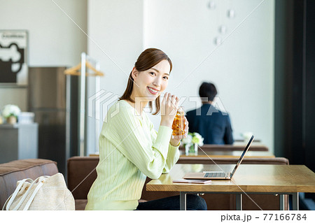 カフェでテレワークをする若い女性 カフェでテレワークをする若い女性 77166784