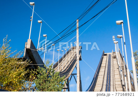 Abandoned wooden ski jumping hill on blue sky background in Kouvola, Finland Abandoned wooden ski jumping hill on blue sky background in Kouvola, Finland 77168921