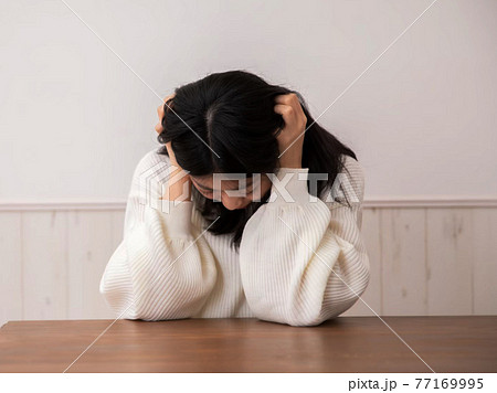 頭を抱える女性 77169995