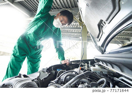 マスクを装着して作業をする自動車整備士 77171644