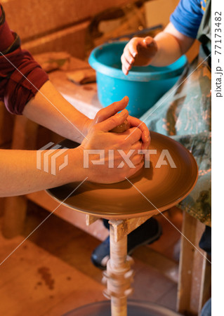 Potter's hands. Making clay products on a potter's wheel. Pottery master class. 77173482