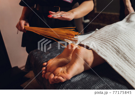 massage of female feet with bamboo sticks. massage of female feet with bamboo sticks. 77175845