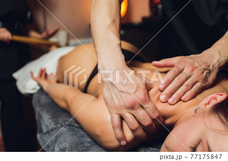 An attractive caucasian woman lying down on a massage bed at a spa. 77175847