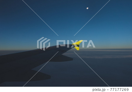 View of the moon and the wing from the window of a flying plane. 77177269