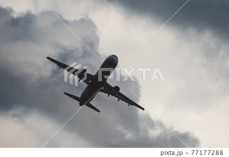 Silhouette of a plane taking off against the blue sky 77177288