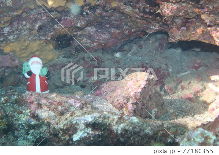 海の岩場にあるサンタクロース像 77180355