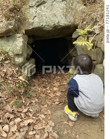 洞穴を覗き込む男の子 77181241