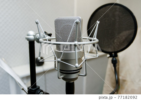 Professional microphone on the background of a light wall. Studio microphone for professional recording. Sound recording studio. Professional microphone on the background of a light wall. Studio microphone for professional recording. Sound recording studio. 77182092