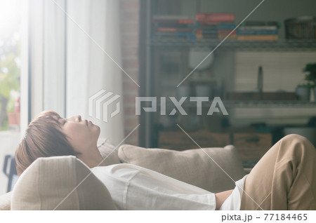 ソファーに座って昼寝する若い女性 ソファーに座って昼寝する若い女性 77184465