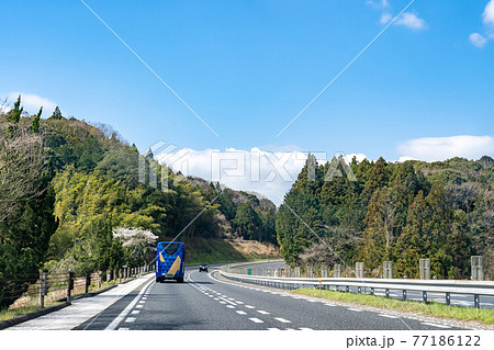 山口県　桜咲く山陽自動車道を走行中の観光バス 77186122