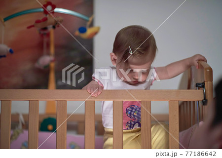 cute little one year old baby and making first steps in bed cute little one year old baby and making first steps in bed 77186642