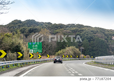 山口県下関市　もうすぐ小月インターチェンジの出口を通りかかる乗用車 77187204