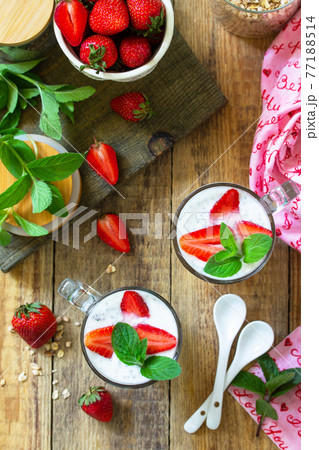 Healthy eating. Breakfast concept. Homemade granola with strawberry, yogurt, chia seeds and fresh berries on a rustic table. Top view flat lay. 77188514