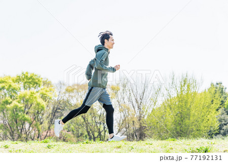 公園でランニングをする若い男性 77192131