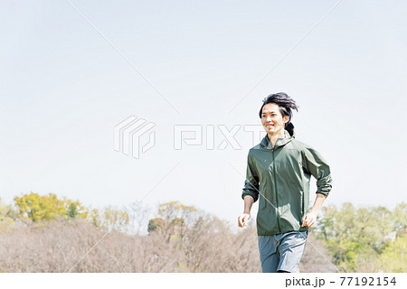 公園でランニングをする若い男性 77192154