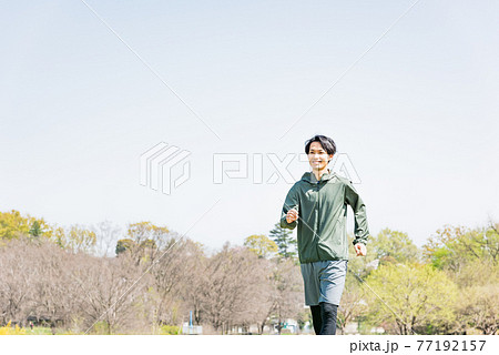 公園でランニングをする若い男性 公園でランニングをする若い男性 77192157