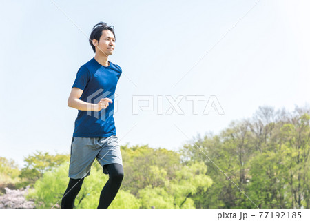 公園でランニングをする若い男性 77192185