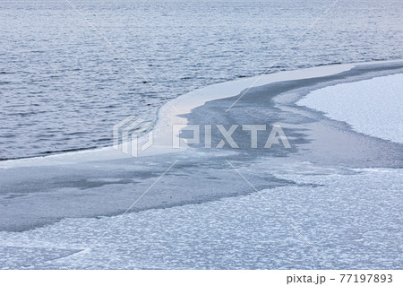 Partially frozen lake surface and snow Partially frozen lake surface and snow 77197893