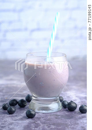blue berry milk shake in a glass on table blue berry milk shake in a glass on table 77199145