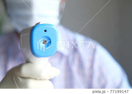 Hand holding infrared thermometer to measuring temperature. Hand holding infrared thermometer to measuring temperature. 77199147