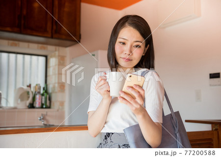 スマホで予定を確認する女性 77200588