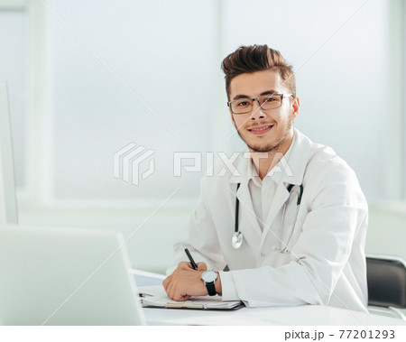doctor therapist sitting at a table in his office doctor therapist sitting at a table in his office 77201293