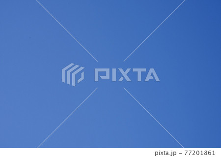 青い空にカメラのセンサー汚れが黒い点として写るイメージ素材 77201861