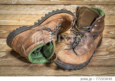 old heavy hiking boots agains wood 77203640