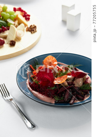 Beet summer salad with arugula, radicchio, soft cheese and walnuts on plate dressing and spices on blue plate, copy space, top view Beet summer salad with arugula, radicchio, soft cheese and walnuts on plate dressing and spices on blue plate, copy space, top view 77205755