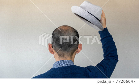 ハゲ坊主の日本人男性が帽子をとって挨拶 後ろ姿の写真素材