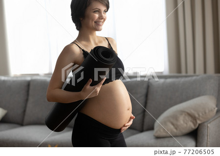 Smiling active pregnant woman with yoga mat Smiling active pregnant woman with yoga mat 77206505