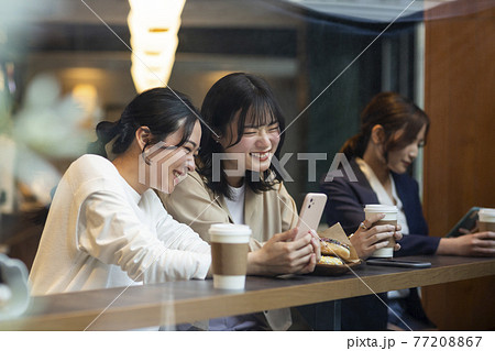 カフェで過ごす若い女性 77208867