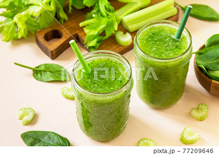 Vegan smoothie recipe. Healthy diet and nutrition, vegan and alkaline drink. Green fresh smoothie with celery and spinach on a pink background. 77209646