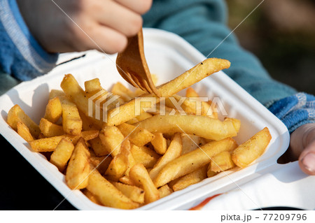 Child eats french fries. Unhealthy food, takeaway and ordering at home 77209796