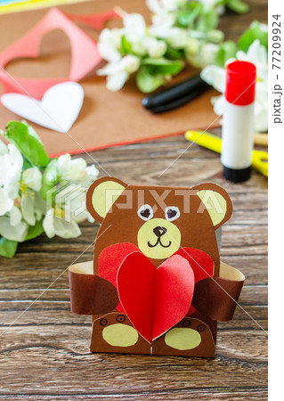 Mother's Day greeting card gift - teddy bear with a heart on a wooden table. Childrens creativity project, handmade, crafts for kids. Mother's Day greeting card gift - teddy bear with a heart on a wooden table. Childrens creativity project, handmade, crafts for kids. 77209924