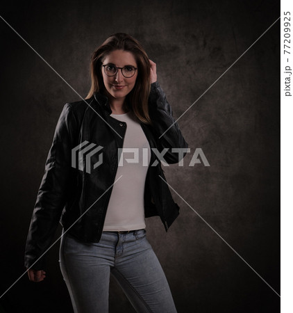 Close-up of a young attractive woman against dark grey background Close-up of a young attractive woman against dark grey background 77209925