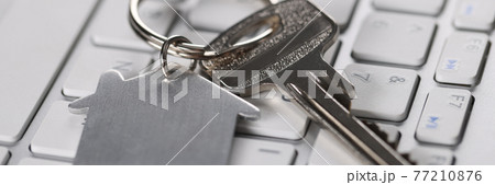 On keyboard are keys with the house keychain 77210876