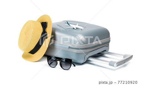 Hello summer. Womens accessories traveler: suitcase, straw hat, sunglasses and toy plane isolated on white background with empty space for text. Tranquil beach scene with copy space. 77210920