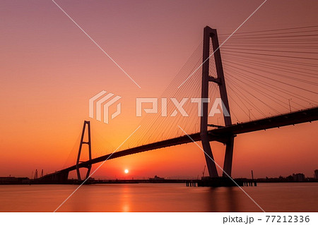 名古屋港 名港トリトン(名港中央大橋)の夕景と沈む太陽 名古屋港 名港トリトン(名港中央大橋)の夕景と沈む太陽 77212336